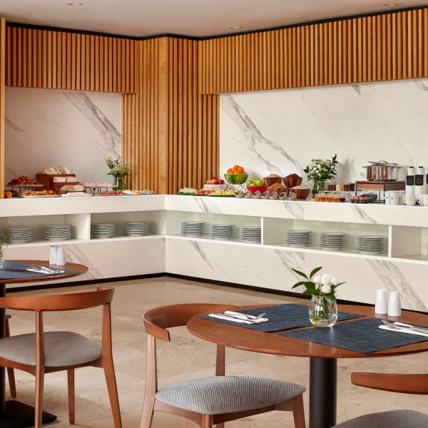 NH_Luz_Huelva_Buffet_Breakfast_Overview_Natural_Light_Food_Tables_Chairs_Flowers_Cutlary_Plates