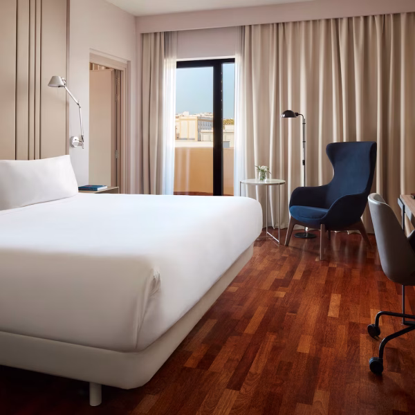 NH_Luz_Huelva_Room_Junior_Suite_Overview_Terrace_Bed_Sofa_Desk_Glass_Book_Lamps_Open_Curtains